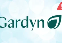 The Gardyn logo features green text with a stylized leaf symbol as the letter y and a small red triangle with an exclamation mark in the top right corner, set against a light, blurred background.