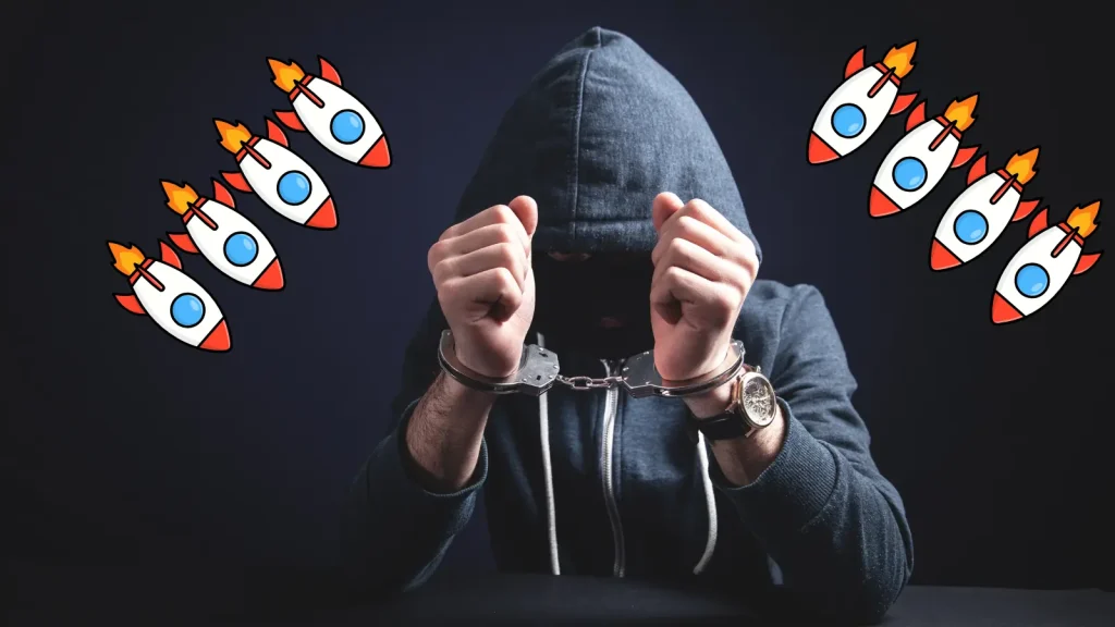 KimWolf-DDoS-Botnet-Operator-Arrested-1024×576 A person in a hooded sweatshirt sits with their hands in handcuffs, head bowed. Cartoon rocket icons are illustrated around them against a dark background.