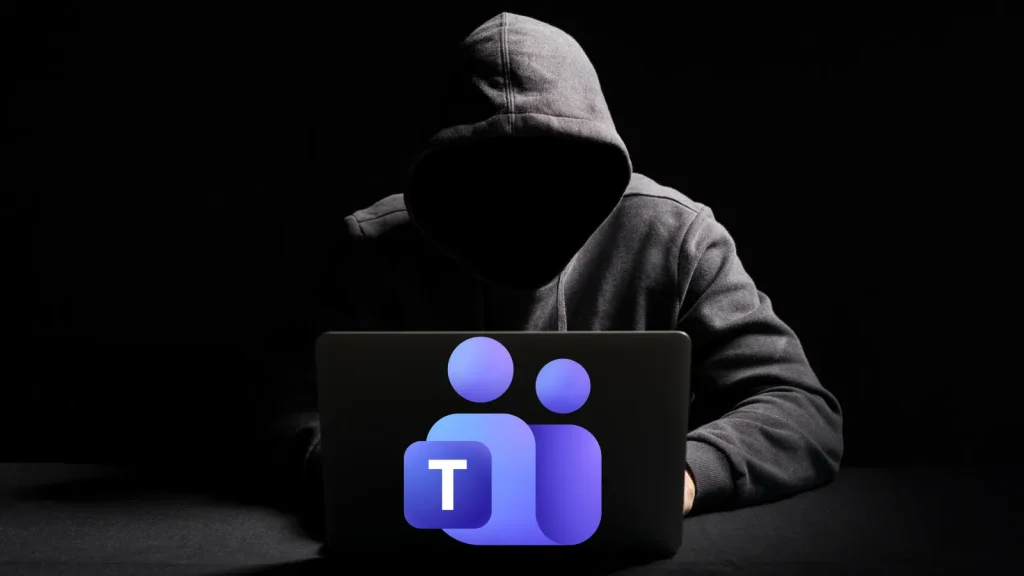 Hackers-Weaponize-Microsoft-Teams-Relay-to-hide-malware-Traffic-1024×576 A person in a dark hoodie sits at a laptop with their face hidden in shadow. The Microsoft Teams logo is prominently displayed on the laptop, suggesting themes of hacking or cybersecurity risks.