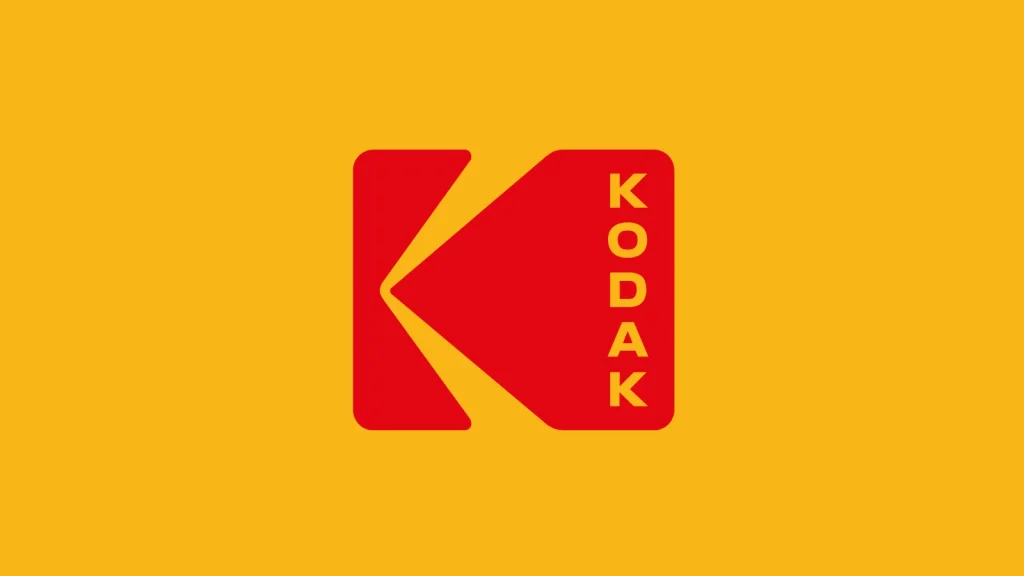 A red stylized K logo with the word KODAK written vertically in yellow letters on the right, set against a solid yellow background.